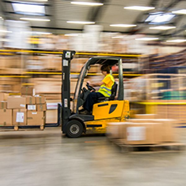 A person driving a forklift in a warehouse